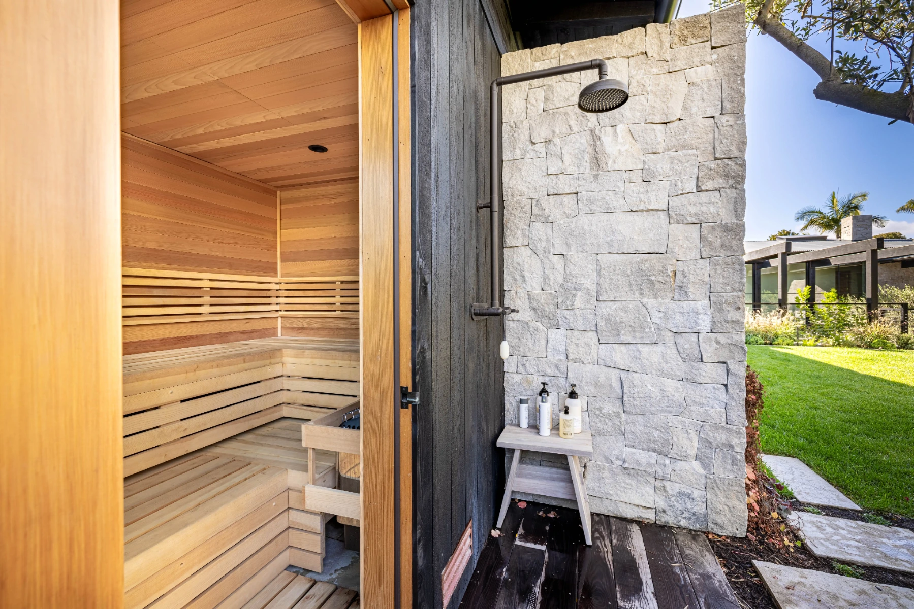 Custom cedar outdoor sauna with an adjacent outdoor shower, providing a convenient way to cool down and transition between sauna sessions.