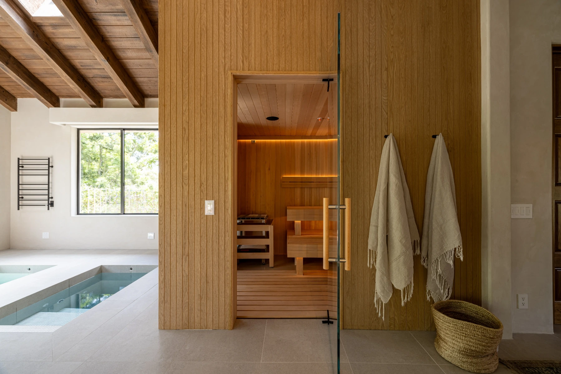Modern home wellness space featuring a custom cedar sauna beside an indoor cold plunge, creating a dedicated environment for contrast therapy and relaxation.