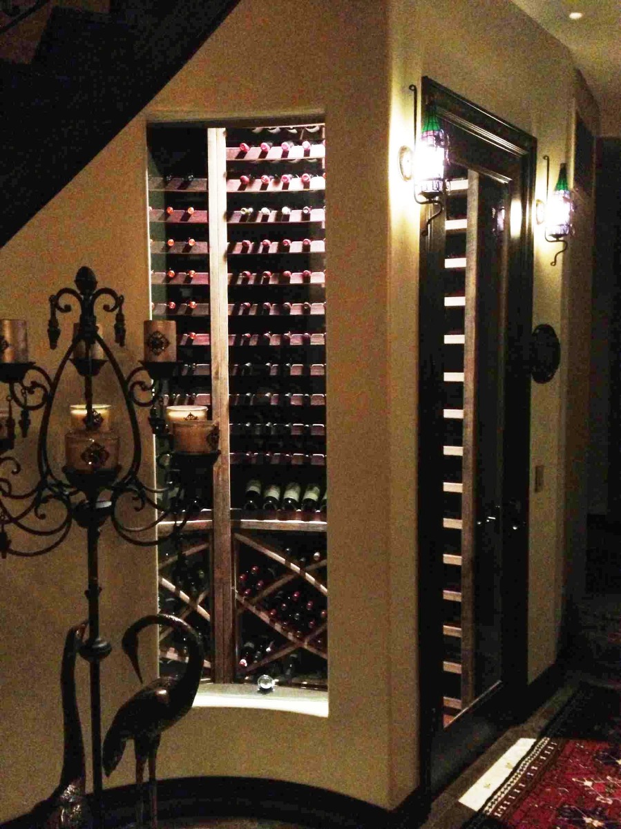 Custom wine cellar walls curve with the staircase above, the wine racks themselves are curved 