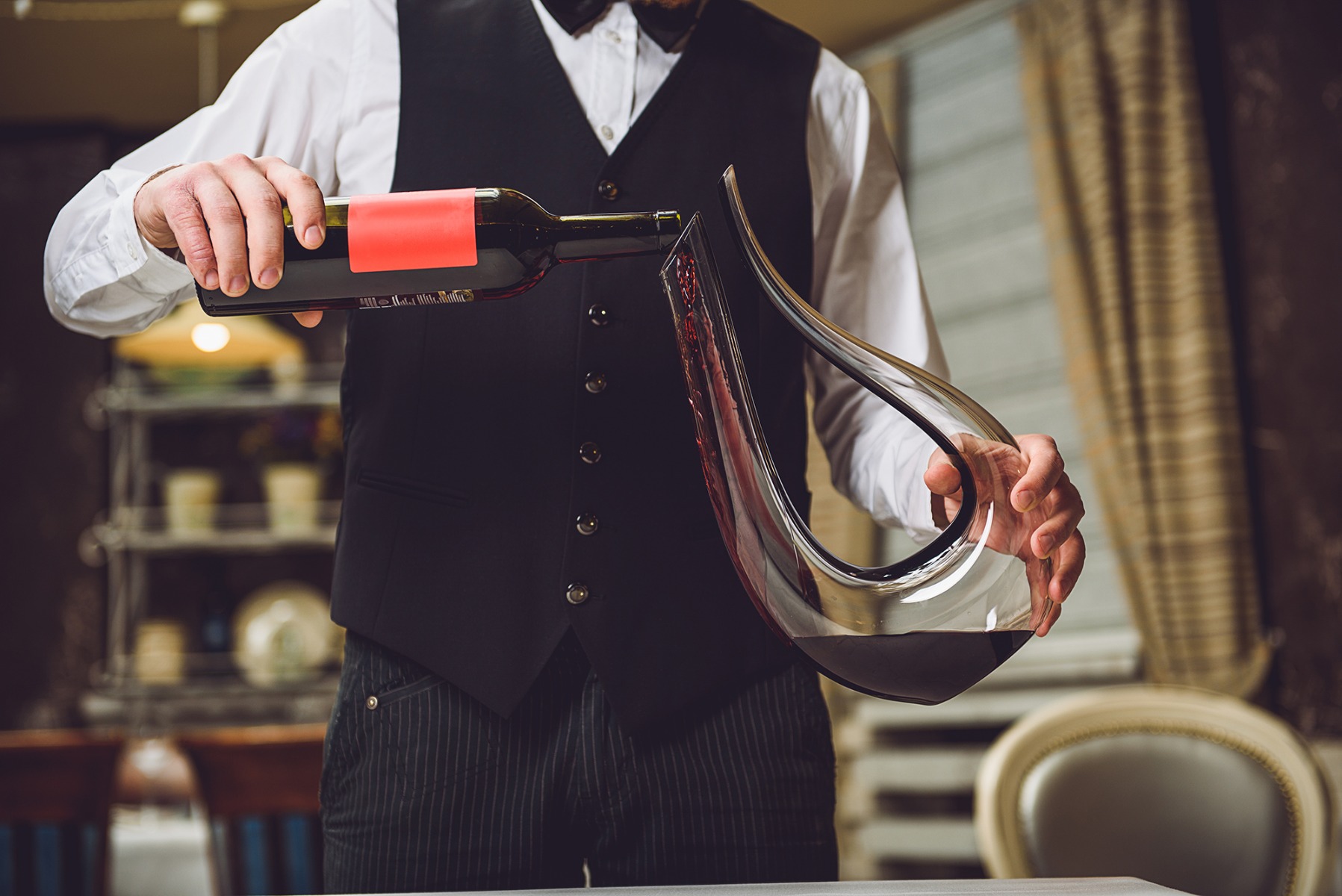 Waiter decanting red wine